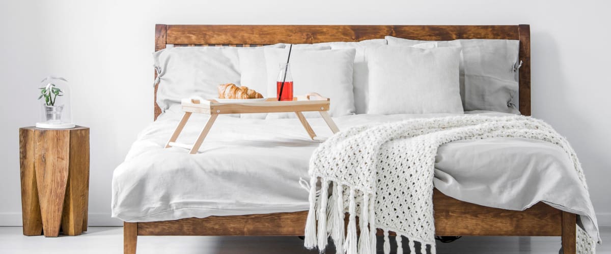 Stock image of modest, wooden bedroom set at Solaire 8200 Dixon in Silver Spring, Maryland