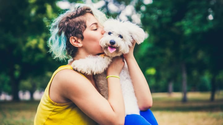 Resident giving her puppy a kiss at a park near Olympus Willow Park in Willow Park, Texas