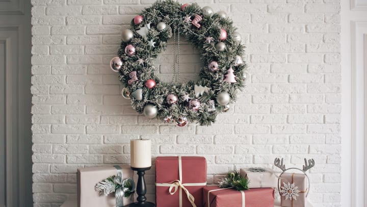 Festive table with holiday decorations and a wreath hanging above