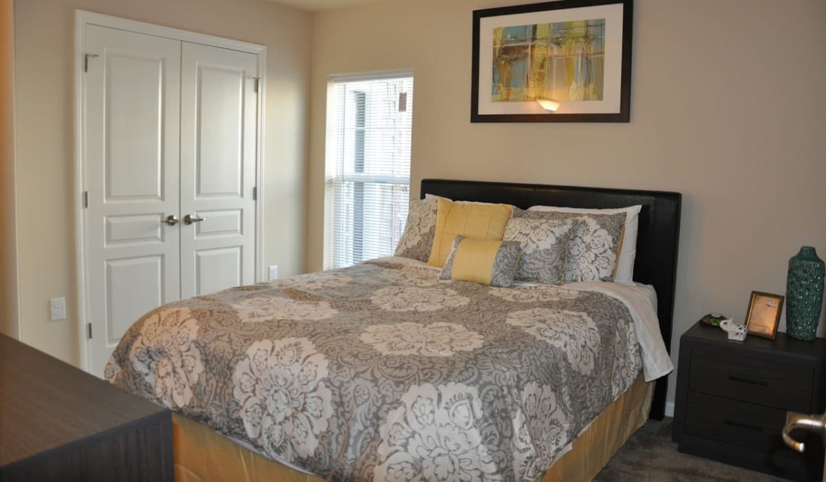 A spacious bedroom with plush carpeting at Denbigh Village in Newport News, Virginia