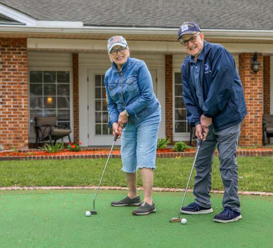 Resident friends playing putt putt golf at Merrill Gardens at Rolling Hills Estates in Rolling Hills Estates, California