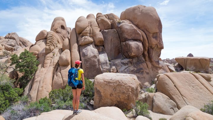 Woman hiking and admiring a beautiful rock formation.