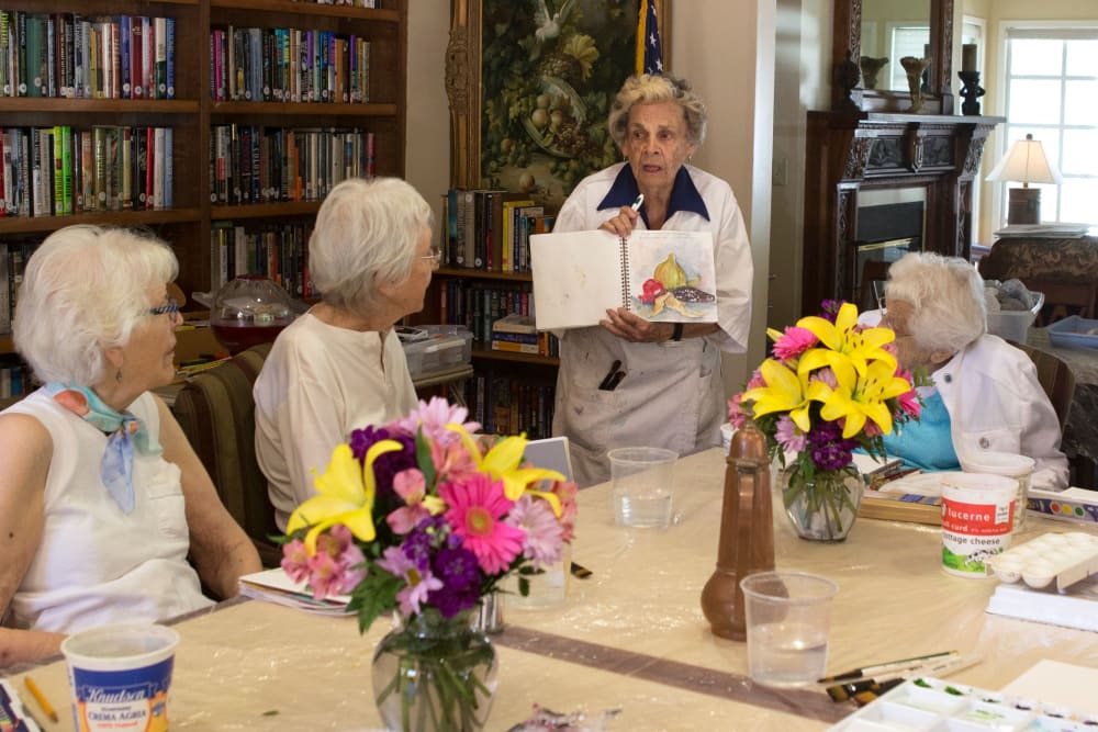 A resident showing other residents her artwork at Gables of Ojai in Ojai, California