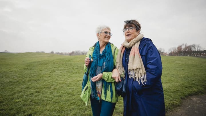 Two older women walking in a park
