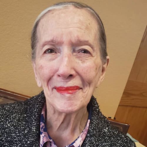 Resident sitting and smiling at Oxford Glen Memory Care at Sachse in Sachse, Texas