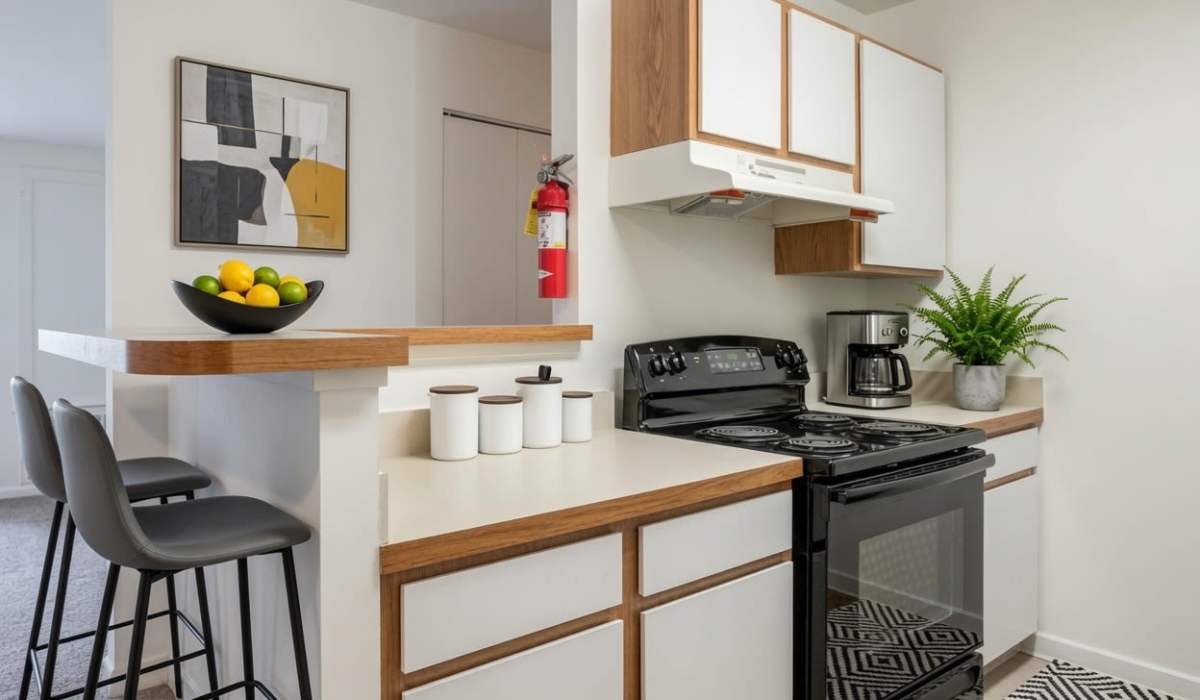Kitchen with black range and wooden cabinets at The Vinings at Christiana Apartments in Newark, Delaware
