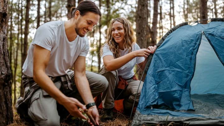 young couple setting up their camping tent | Jacksonville campgrounds 