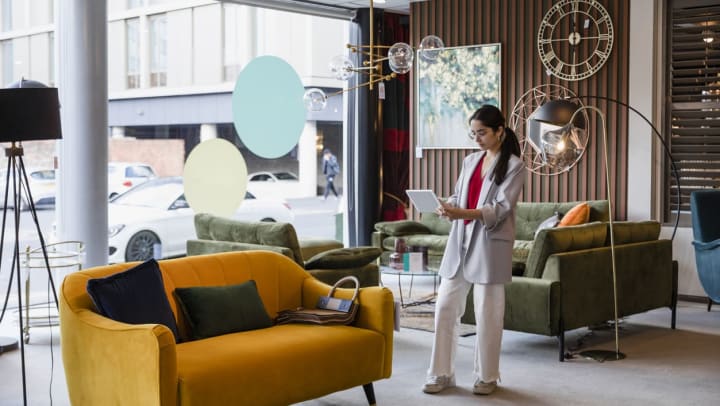 A young woman snaps a picture of an orange couch in a Willow Park furniture store.
