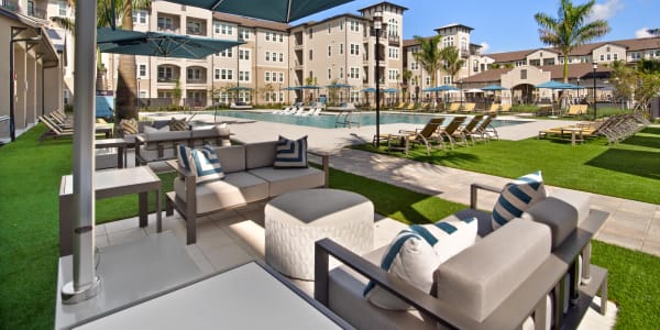Outdoor lounge areas and umbrellas at Murano at Three Oaks in Fort Myers, Florida