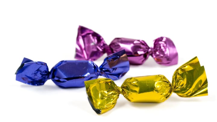 Candy in colorful foil on white background.