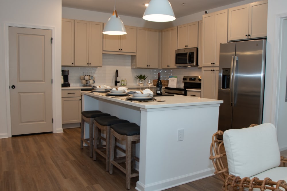 High-end kitchen with white cabinetry and a large adaptable island at Primrose at Santa Rosa Beach in Santa Rosa Beach, Florida