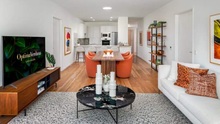 Bright living area with modern décor, open kitchen, and stylish seating at Optima Verdana.