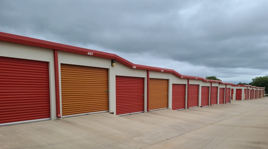 Exterior view of storage units with red and orange doors at KO Storage of Wichita Falls in Wichita Falls, Texas