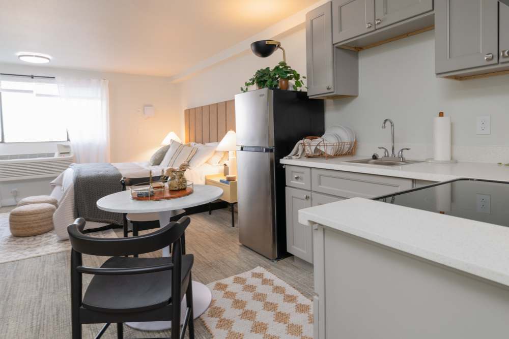 Furnished model apartment home with efficient kitchen with slow close drawers and storage in custom cabinetry at Thea Apartments in Tacoma, Washington.