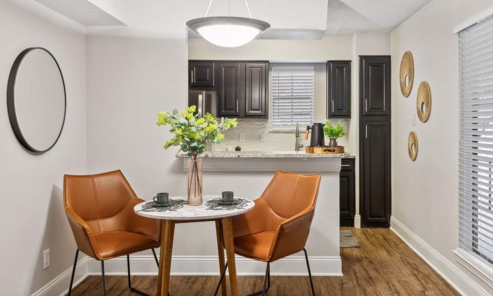 A furnished apartment living room and bar seating at the kitchen peninsula at Verandahs at Cliffside Apartments in Arlington, Texas