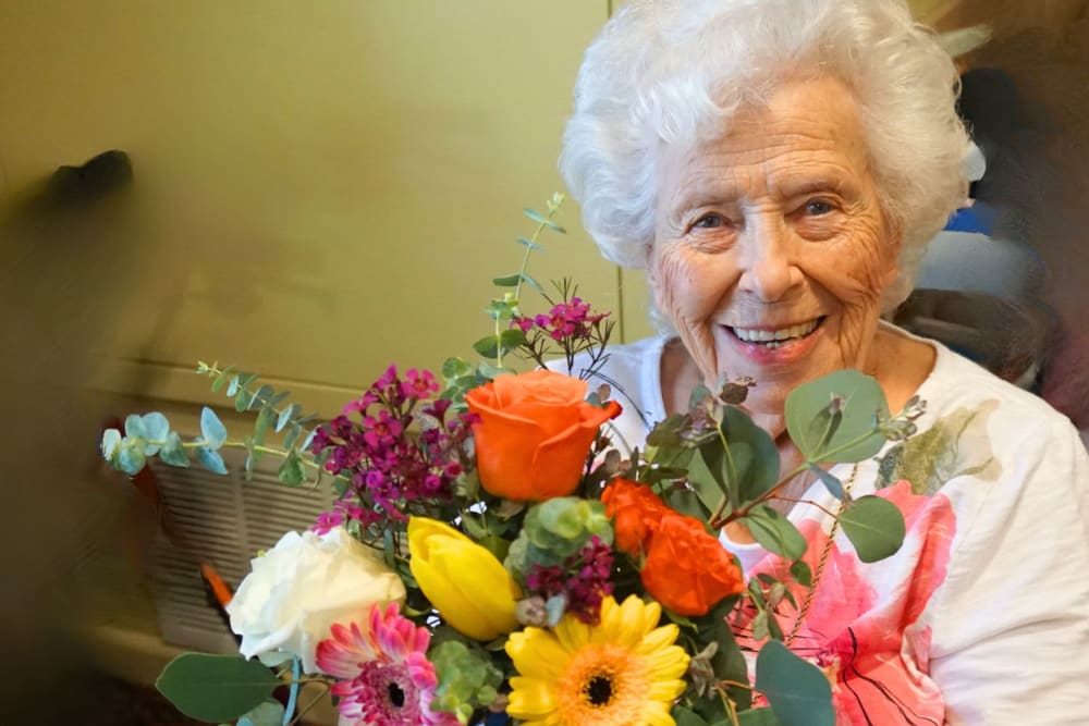 Resident with a bouquet of flowers at Winding Commons Senior Living in Carmichael, California