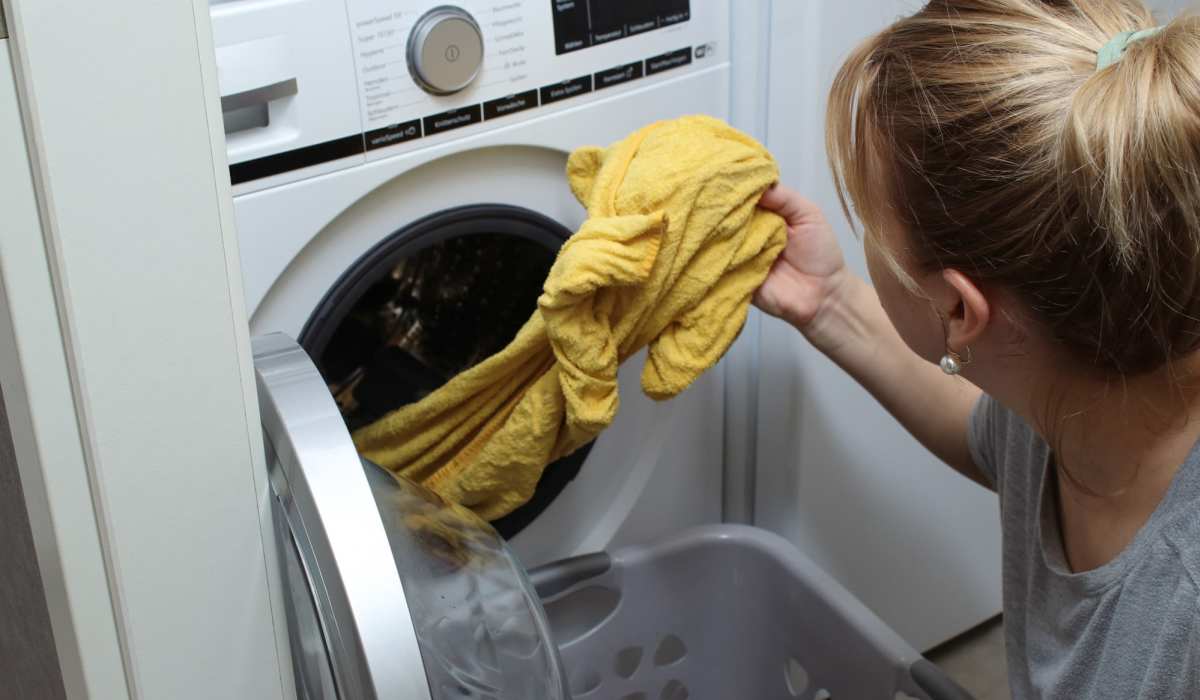 Resident woman unloading clothes from washing machine at Napa Creek Terrace in Napa, California