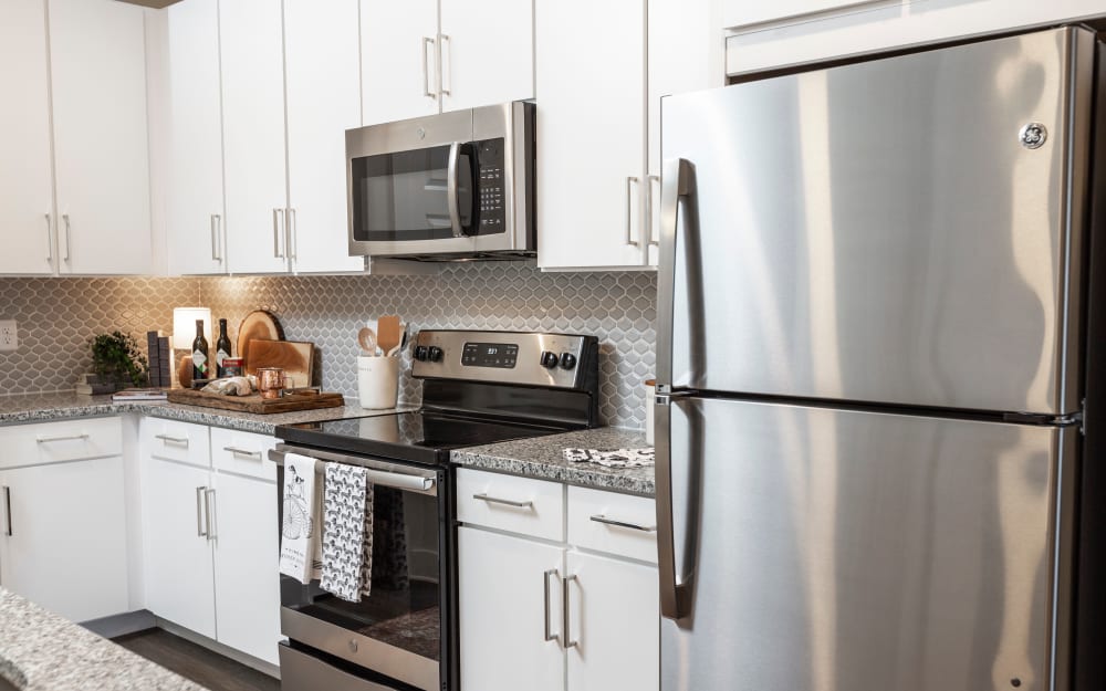 Granite countertops and a subway tile backsplash in model home's kitchen at Parc at Wesley Chapel in Wesley Chapel, Florida