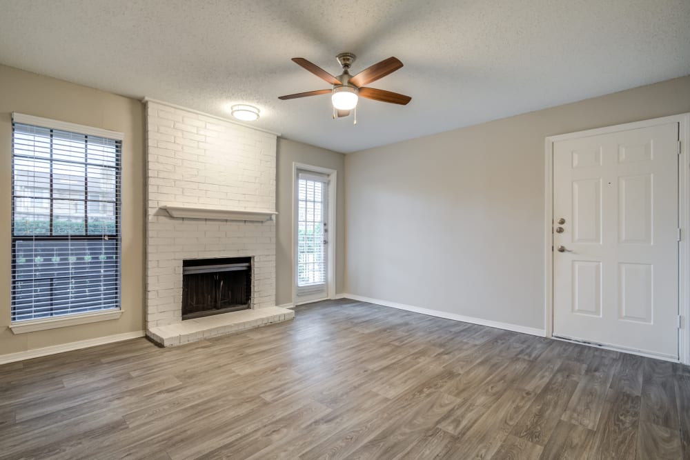 Hardwood floors and a fireplace in the open-concept floor plan of a model home at The Arbors of Carrollton in Carrollton, Texas