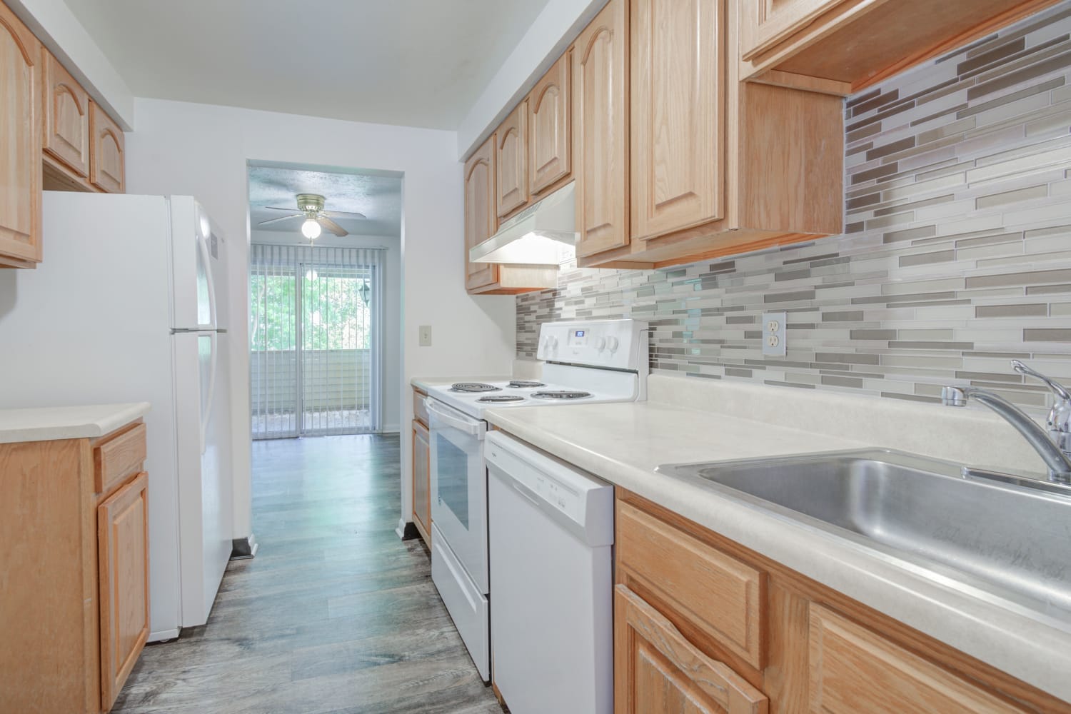 Kitchen with maple cabinets and white appliances at Riverton Knolls in West Henrietta, New York
