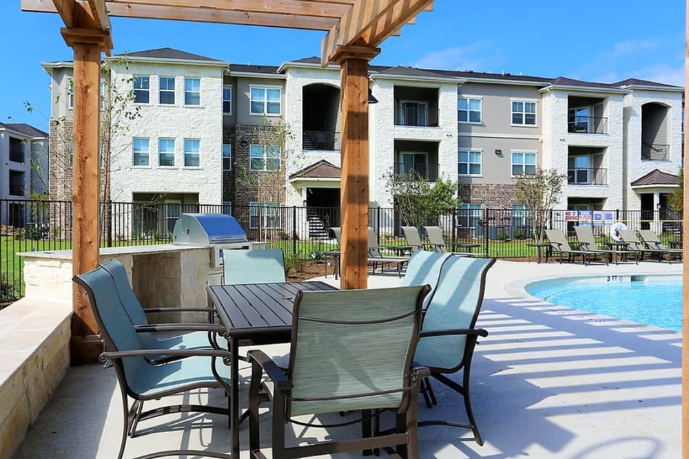 Poolside patio tables at Trails at Lake Houston in Houston, Texas