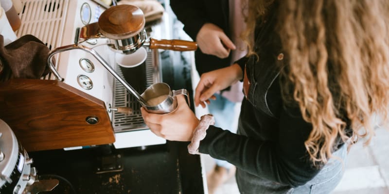 A barista steaming milk at a coffee shop near O'Neill Heights in Oceanside, California