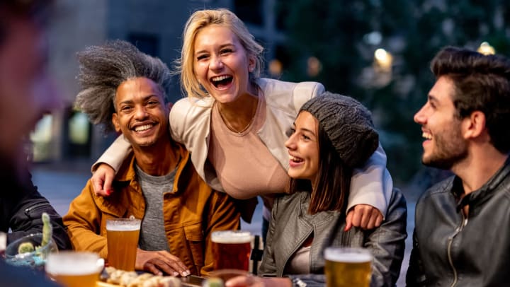 Group of people smiling and drinking at brewery