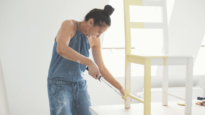 Resident painting a chair in her new home at The Enclave in Brunswick, Georgia
