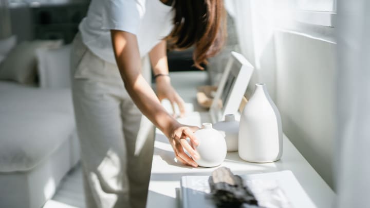 Woman arranging porcelain vases on white table at Olympus at the District in South Jordan, Utah