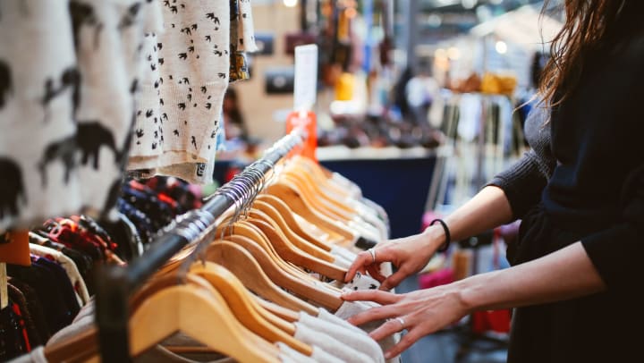 Woman looking at a rack of clothes at an outdoor market