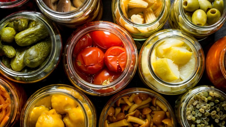 An eagle eye view of an array of pickled goods in open jars.