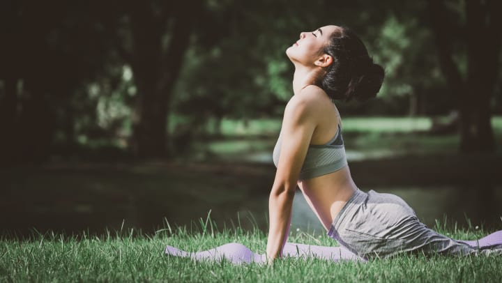Woman doing yoga on mat in park
