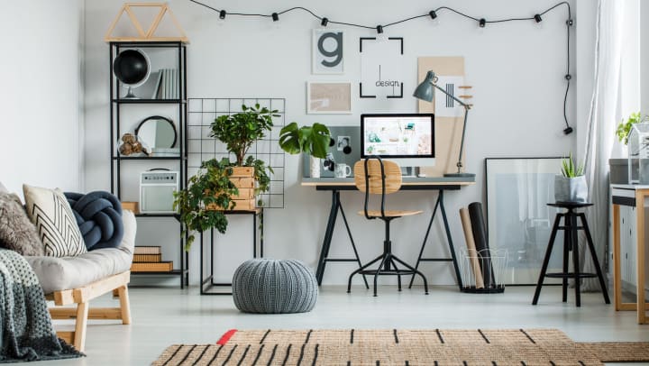 Cozy and minimal interior design with work desk, sofa, rug, and houseplants