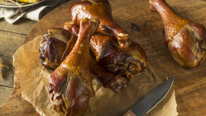 Smoked turkey legs on a cutting board. 