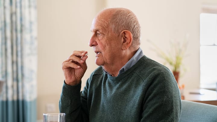 A senior man eating a cracker