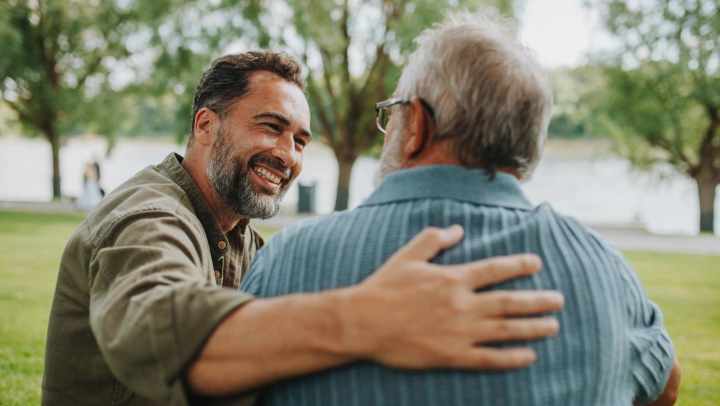 Supportive companion sitting with an older adult outdoors, providing senior care assistance at {{location_name}} in {{location_city}}, {{location_state_name}}