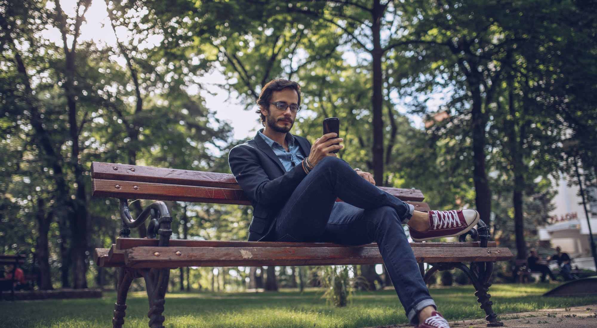 Contact Us | A resident lounging in a park filled with greenery near 140 Sacramento Townhomes in Portland, Oregon