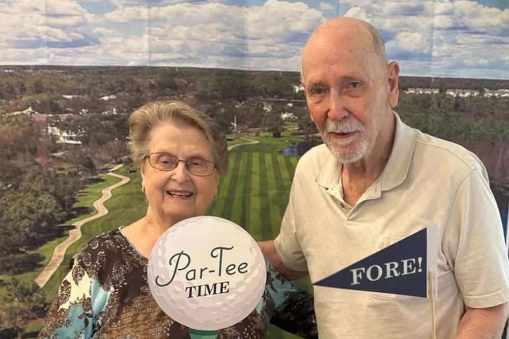 Caretakers posing with props for a photo with a resident at The Blake at Bossier City in Bossier City, Louisiana