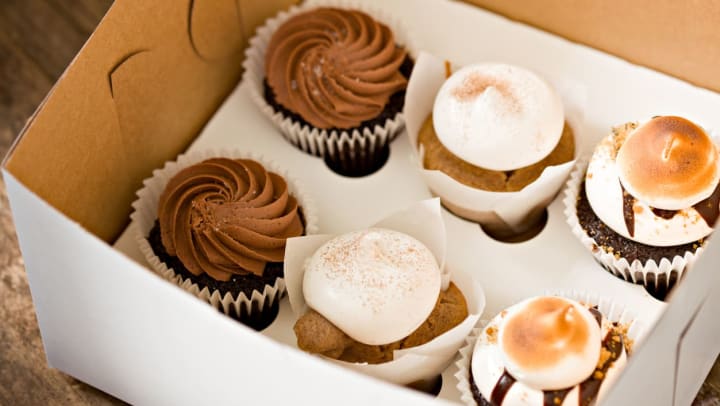 Assorted specialty cupcakes in a to-go box