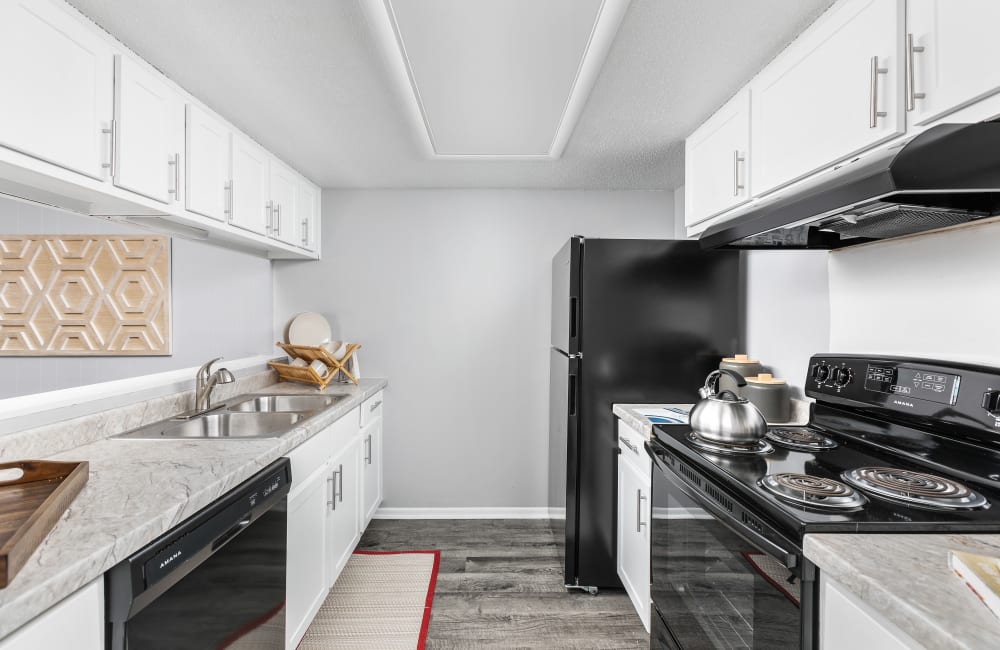 Kitchen with modern white cabinets and black appliances at Astoria Park Apartment Homes in Indianapolis, Indiana