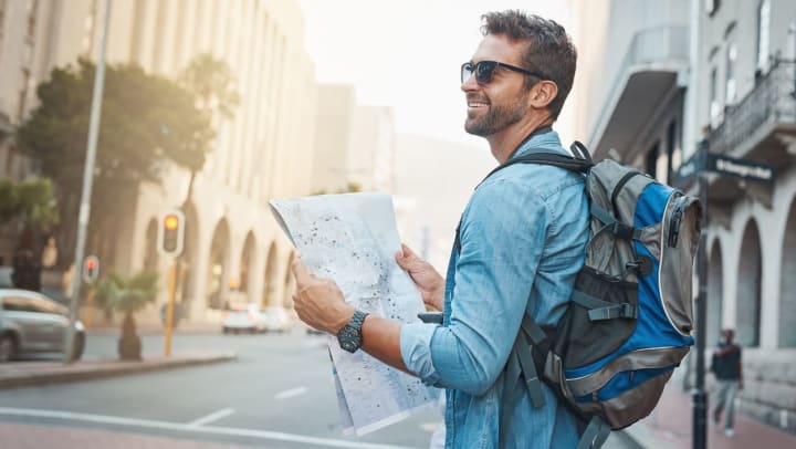 Man holding a map while touring the city