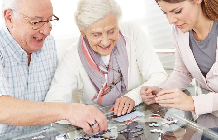 Family putting together a puzzle at Stonecrest of Troy in Troy