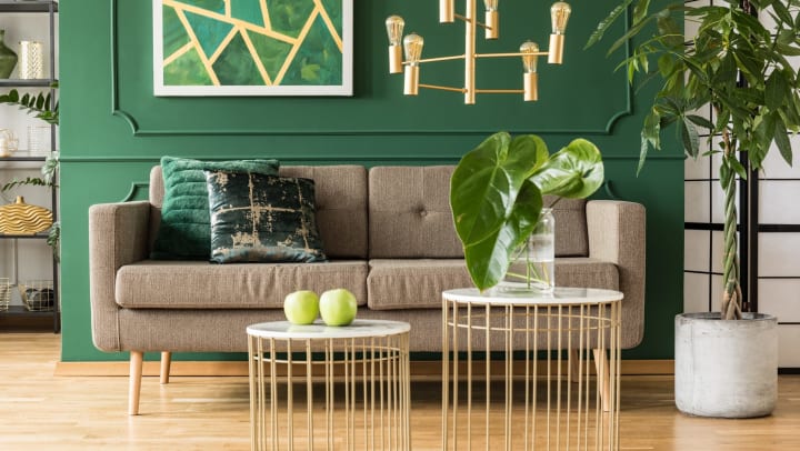 Elegant green and gold living room with comfortable sofa.