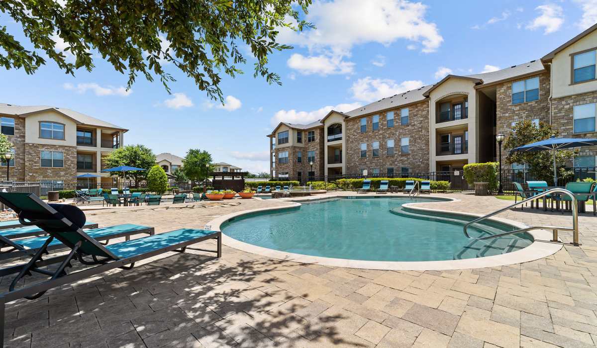 Swimming pool with deck chairs at Lebanon Ridge in Frisco, Texas