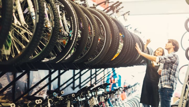 Two people examining a row of bikes at a South Jordan bike shop.