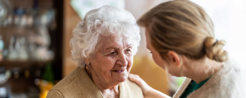 A staff member talking to a resident at Chateau Gardens Memory Care in Springfield, Oregon