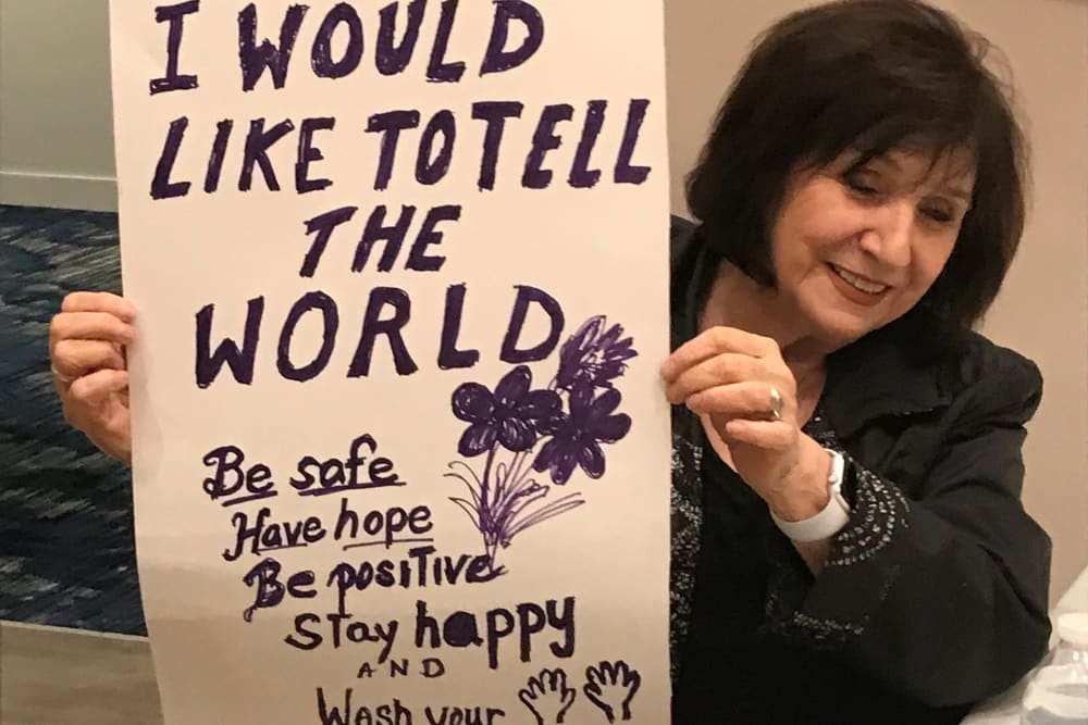 Clearwater resident holds up a positive message sign she created