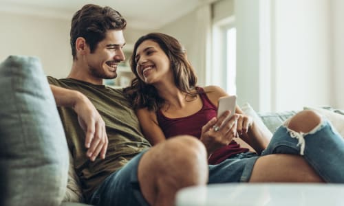 A resident couple sits on their couch at Courtyard in Hayward, California