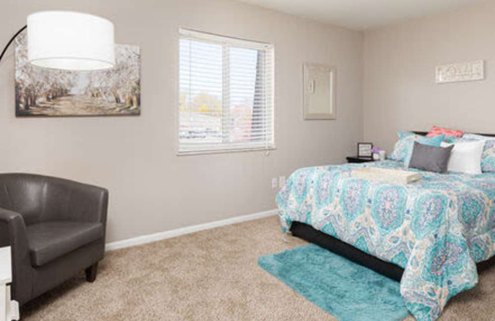 Bedroom with carpet flooring, side lamp, mirror and window at Maple Oaks in Middletown, Ohio