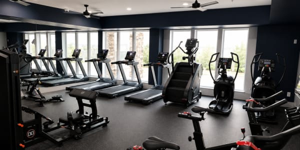 Fitness center with cardio machines and workout equipment at The Den in Columbia, Missouri